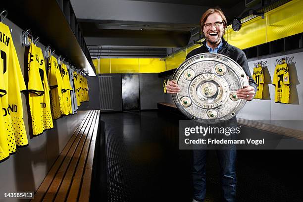 Head coach Juergen Klopp of German Bundesliga football club Borussia Dortmund poses with the German Championships Bundesliga throphy during a...