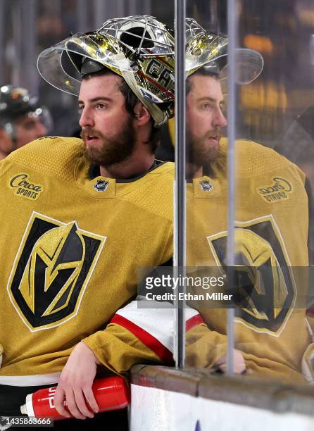 Logan Thompson of the Vegas Golden Knights is reflected in the glass as he takes a break during a stop in play in the third period of a game against...
