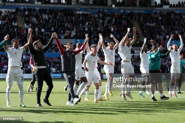 Players of Swansea City celebrates their side's win in front of their fans with Russell Martin, Manager of Swansea City, after the final whistle of...