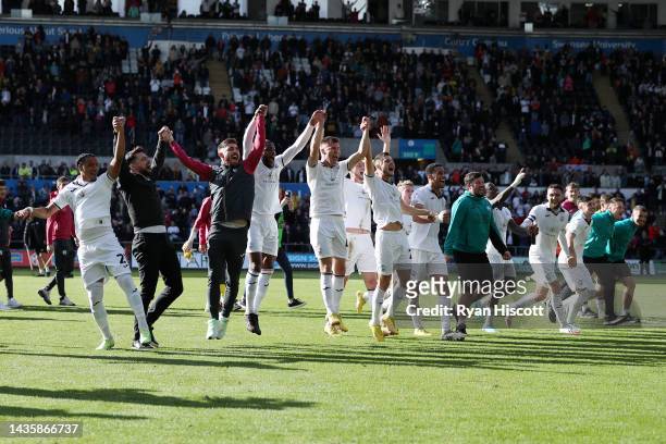Players of Swansea City celebrates their side's win in front of their fans with Russell Martin, Manager of Swansea City, after the final whistle of...