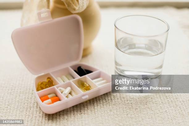 dietary supplements .white container for tablets. a tablet for a glass of water in a transparent glass - vitamin a stock pictures, royalty-free photos & images