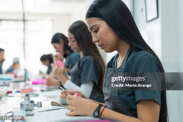 dentistry student performs her exercises in class while working with ceramic teeth - palate stock pictures, royalty-free photos & images