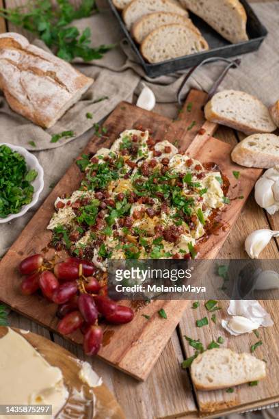 appetizer plate butter board with garlic bacon parsley and herbs in rustic kitchen with white wine glass - chopping board 個照片及圖片檔