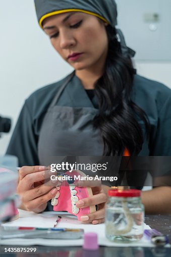 Dentistry student performs her exercises in class while working with ceramic teeth Dentistry student performs her exercises in class while working with ceramic teeth