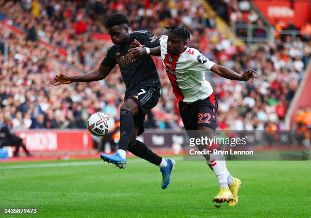 Bukayo Saka of Arsenal is challenged by Mohammed Salisu of Southampton during the Premier League match between Southampton FC and Arsenal FC at...