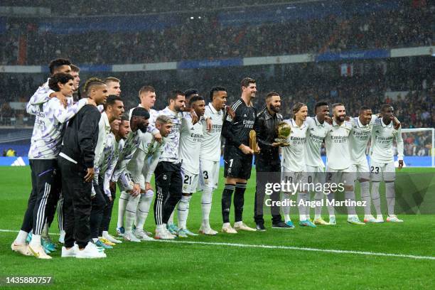 Thibaut Courtois with the Yashin Trophy and Karim Benzema with the Ballon d'Or trophy pose with their teammates prior to the LaLiga Santander match...