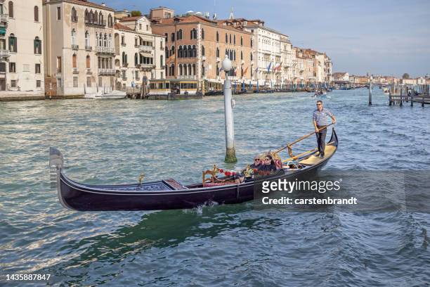 tourists in a gondola on a large canal - gondolier stock pictures, royalty-free photos & images