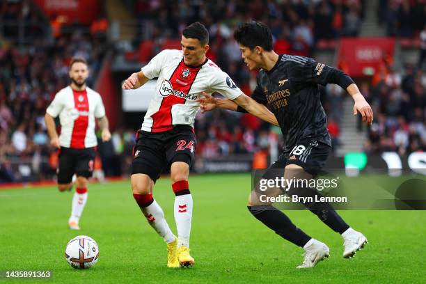 Mohamed Elyounoussi of Southampton is challenged by Takehiro Tomiyasu of Arsenal during the Premier League match between Southampton FC and Arsenal...