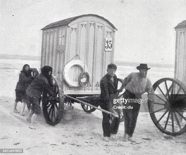 norderney, wooden bathing carts with big wheels at the beach - norderney stock illustrations