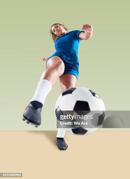 female footballer striking ball toward camera - shooting at goal 個照片及圖片檔