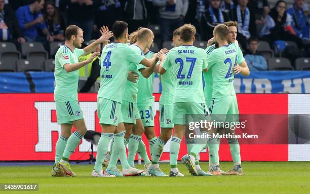 Marius Buelter of FC Schalke 04 celebrates with teammates after scoring their team's first goal during the Bundesliga match between Hertha BSC and FC...