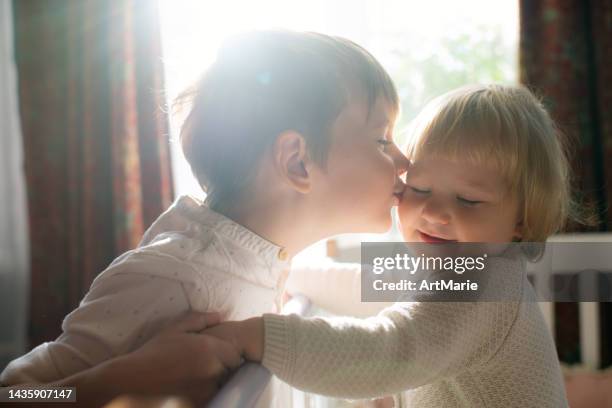 ragazzino che bacia la sua simpatica sorellina - kiss sisters foto e immagini stock