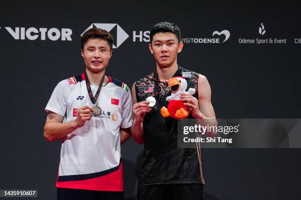 Shi Yuqi of China and Lee Zii Jia of Malaysia pose with their medals on the podium after the Men's Single Final match during day six of the Denmark...