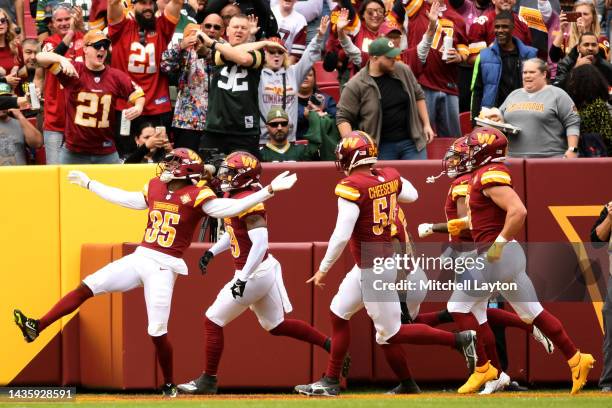 Percy Butler of the Washington Commanders celebrates with his teammates after a defensive stop during the first half of the game against the Green...