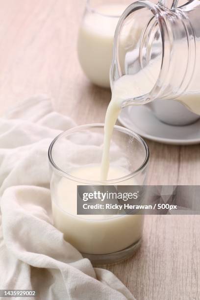 high angle view of milk pouring milk in glass on table - cream dairy product 個照片及圖片檔