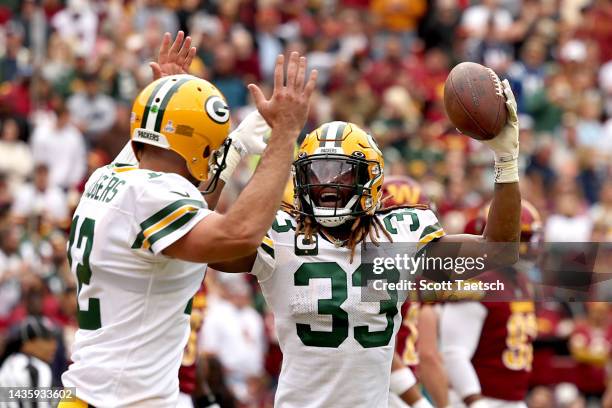 Aaron Jones of the Green Bay Packers celebrates with Aaron Rodgers after a touchdown in the first quarter of the game against the Washington...