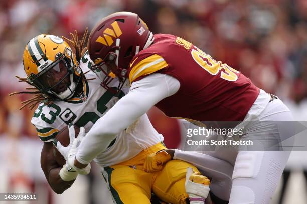 Aaron Jones of the Green Bay Packers is tackled by Montez Sweat of the Washington Commanders during the first quarter of the game at FedExField on...