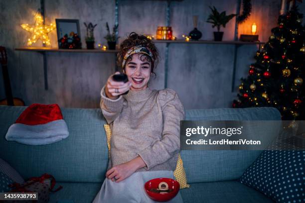 woman watching tv at home - christmas movie stock pictures, royalty-free photos & images