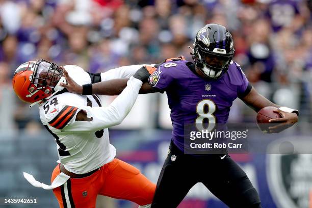 Lamar Jackson of the Baltimore Ravens stiff-arms Deion Jones of the Cleveland Browns during the fourth quarter of the game at M&T Bank Stadium on...