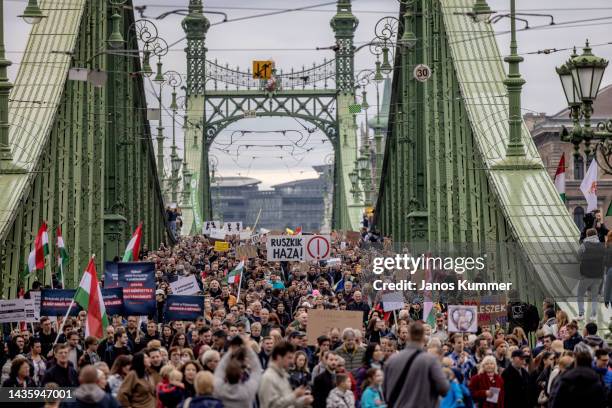 Protestors hold banners during a sympathy march across the Liberty Bridge to show their support for teachers on October 23, 2022 in Budapest,...