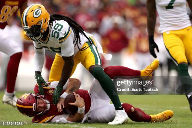 De'Vondre Campbell of the Green Bay Packers sacks Taylor Heinicke of the Washington Commanders during the first half of the game at FedExField on...