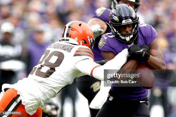 Justice Hill of the Baltimore Ravens fumbles the ball as he is hit by Jeremiah Owusu-Koramoah of the Cleveland Browns during the fourth quarter at...