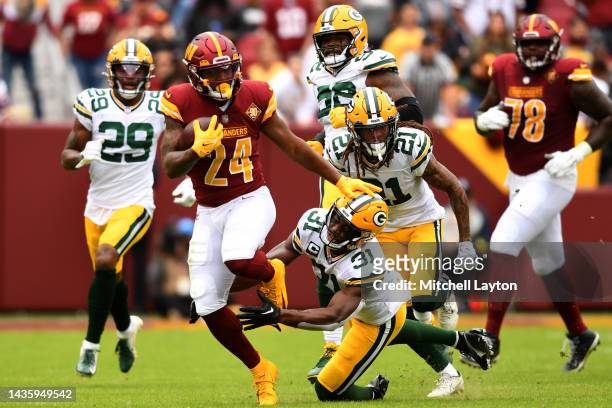Antonio Gibson of the Washington Commanders avoids a tackle by Adrian Amos of the Green Bay Packers during the first half of the game at FedExField...