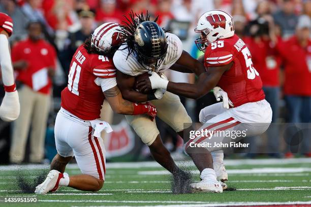 Kobe Lewis of the Purdue Boilermakers rushes the ball while being tackled by Maema Njongmeta and Titus Toler of the Wisconsin Badgers at Camp Randall...