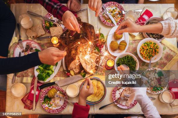 family celebrating christmas at home and playing with sparklers fireworks - christmas meal stock pictures, royalty-free photos & images