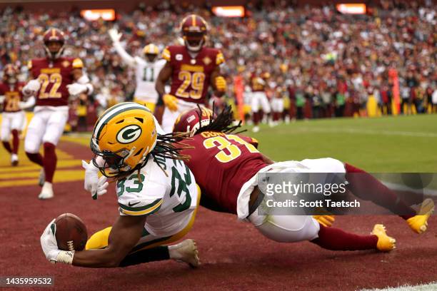 Aaron Jones of the Green Bay Packers completes a touchdown pass during the third quarter of the game against the Washington Commanders at FedExField...