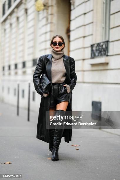 Diane Batoukina wears black leather thigh high pointed boots from Mango, a gray wool turtleneck sweater from Massimo Dutti, a long black leather...