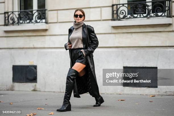 Diane Batoukina wears black leather thigh high pointed boots from Mango, a gray wool turtleneck sweater from Massimo Dutti, a long black leather...