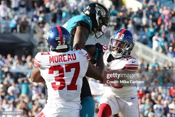 Fabian Moreau and Julian Love of the New York Giants tackle Christian Kirk of the Jacksonville Jaguars short of the goal line on the final play of...