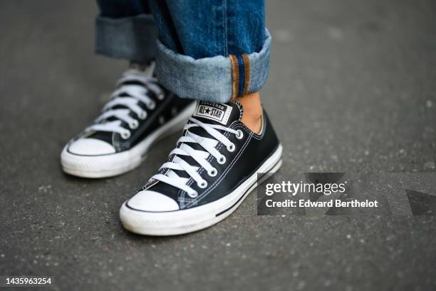 Diane Batoukina wears blue denim jeans / pants with hems from Anine Bing, sneakers / shoes from Converse, during a street style fashion photo...