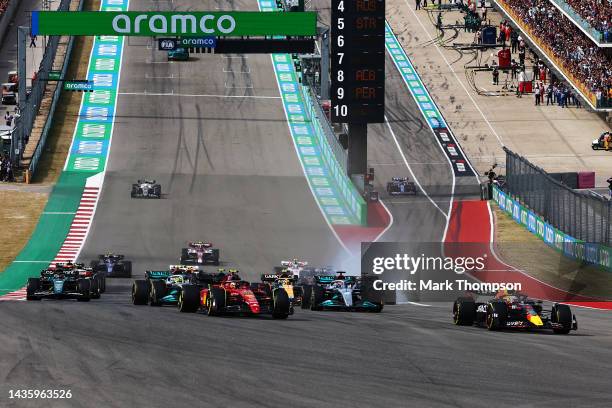 Max Verstappen of the Netherlands driving the Oracle Red Bull Racing RB18 leads Carlos Sainz of Spain driving the Ferrari F1-75 and the rest of the...