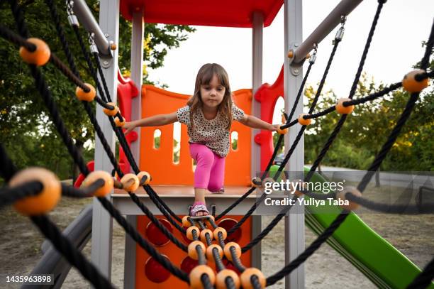 adventure playground. happy little girl playing on the monkey bar - jungle gym stock pictures, royalty-free photos & images