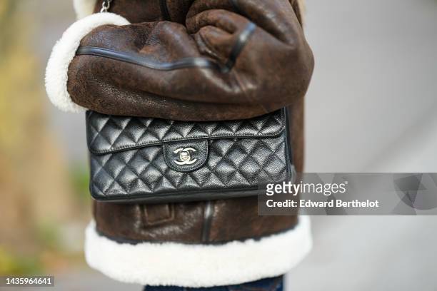 Diane Batoukina wears a brown leather aviator jacket from Massimo Dutti with white sheep wool inner lining, a Chanel bag, during a street style...