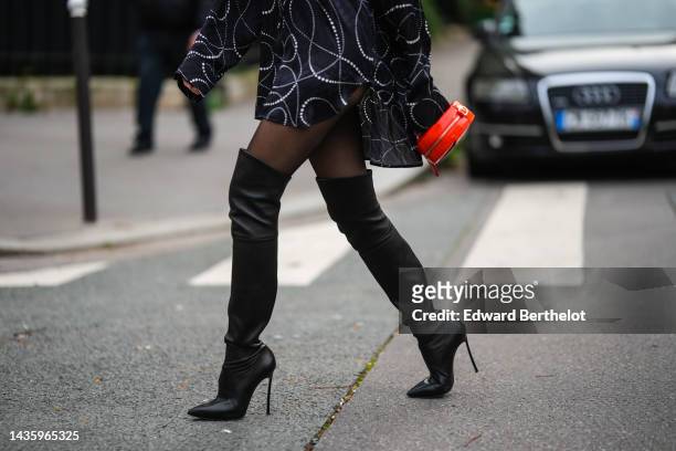 Emy Venturini wears a black and white shirt dress with printed patterns from Balenciaga, black thigh high pointed high heel boots from Casadei, black...
