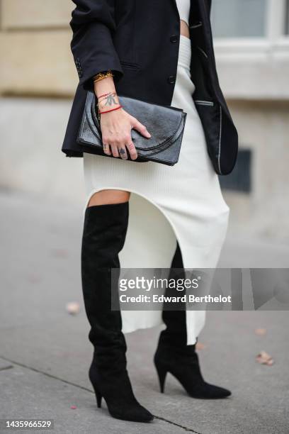 Emy Venturini wears a black oversize blazer jacket from Prada, a white ribbed wool low-neck crop top and matching asymmetric skirt from Adamskaya,...