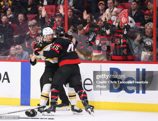 Connor Clifton of the Boston Bruins and Parker Kelly of the Ottawa Senators fight at Canadian Tire Centre on October 18, 2022 in Ottawa, Ontario,...