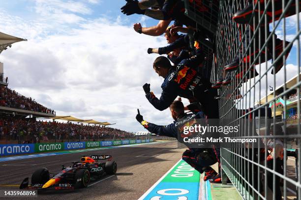 Race winner Max Verstappen of the Netherlands and Oracle Red Bull Racing crosses the finish line as team members celebrate in parc ferme following...