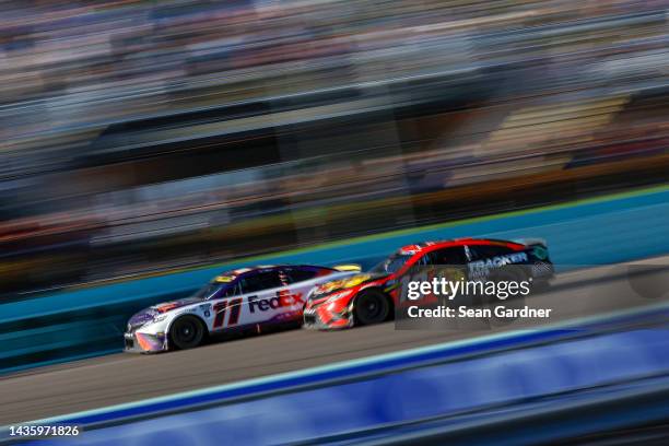 Denny Hamlin, driver of the FedEx Ground Toyota, and Martin Truex Jr., driver of the Bass Pro Shops Toyota, race during the NASCAR Cup Series Dixie...