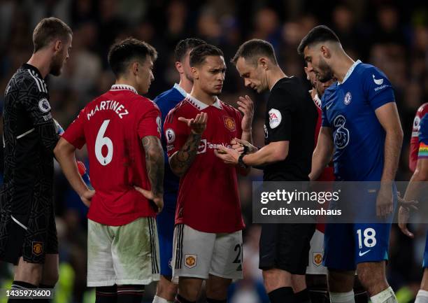 Dos Santos Antony of Manchester United is booked by referee Stuart Attwell after he awarded Chelsea a penalty during the Premier League match between...