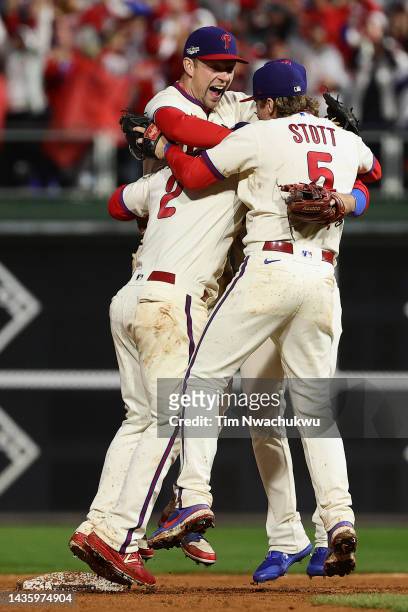 Jean Segura, Bryson Stott and Rhys Hoskins of the Philadelphia Phillies react after defeating the San Diego Padres in game five to win the National...