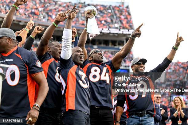 Denver Broncos greats Shannon Sharpe and Terrell Davis lead the team in hoisting the Lombardi Trophy during a halftime celebrations celebrating the...