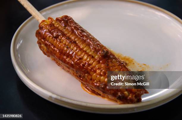 elote con mayonesa de hormiga chicatana (sweetcorn on the cob with chicatana ant mayonnaise) on a plate - hormiga stock pictures, royalty-free photos & images