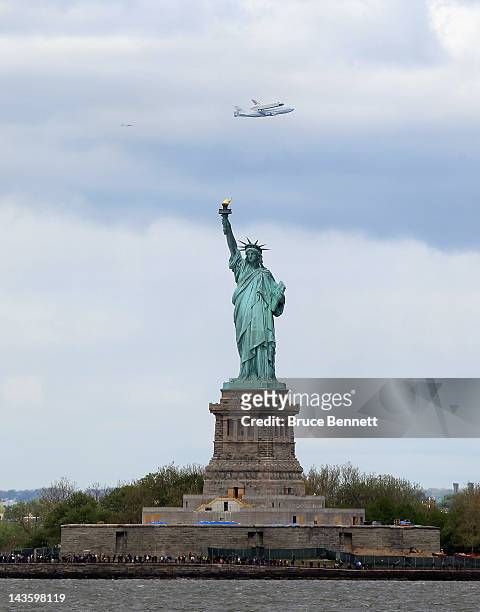 Riding atop a 747 shuttle carrier aircraft, the space shuttle Enterprise flies past the Statue of Liberty in New York Harbor on April 27, 2012 in New...