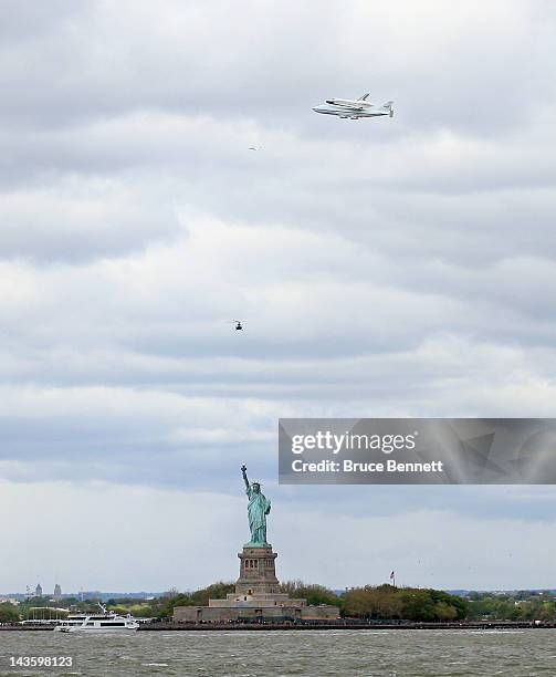 Riding atop a 747 shuttle carrier aircraft, the space shuttle Enterprise flies past the Statue of Liberty in New York Harbor on April 27, 2012 in New...