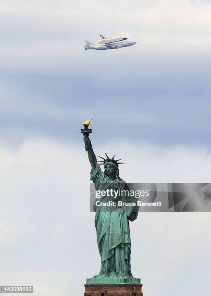 Riding atop a 747 shuttle carrier aircraft, the space shuttle Enterprise flies past the Statue of Liberty in New York Harbor on April 27, 2012 in New...