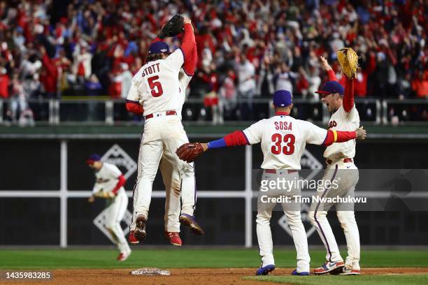Jean Segura, Bryson Stott and Rhys Hoskins of the Philadelphia Phillies react after defeating the San Diego Padres in game five to win the National...